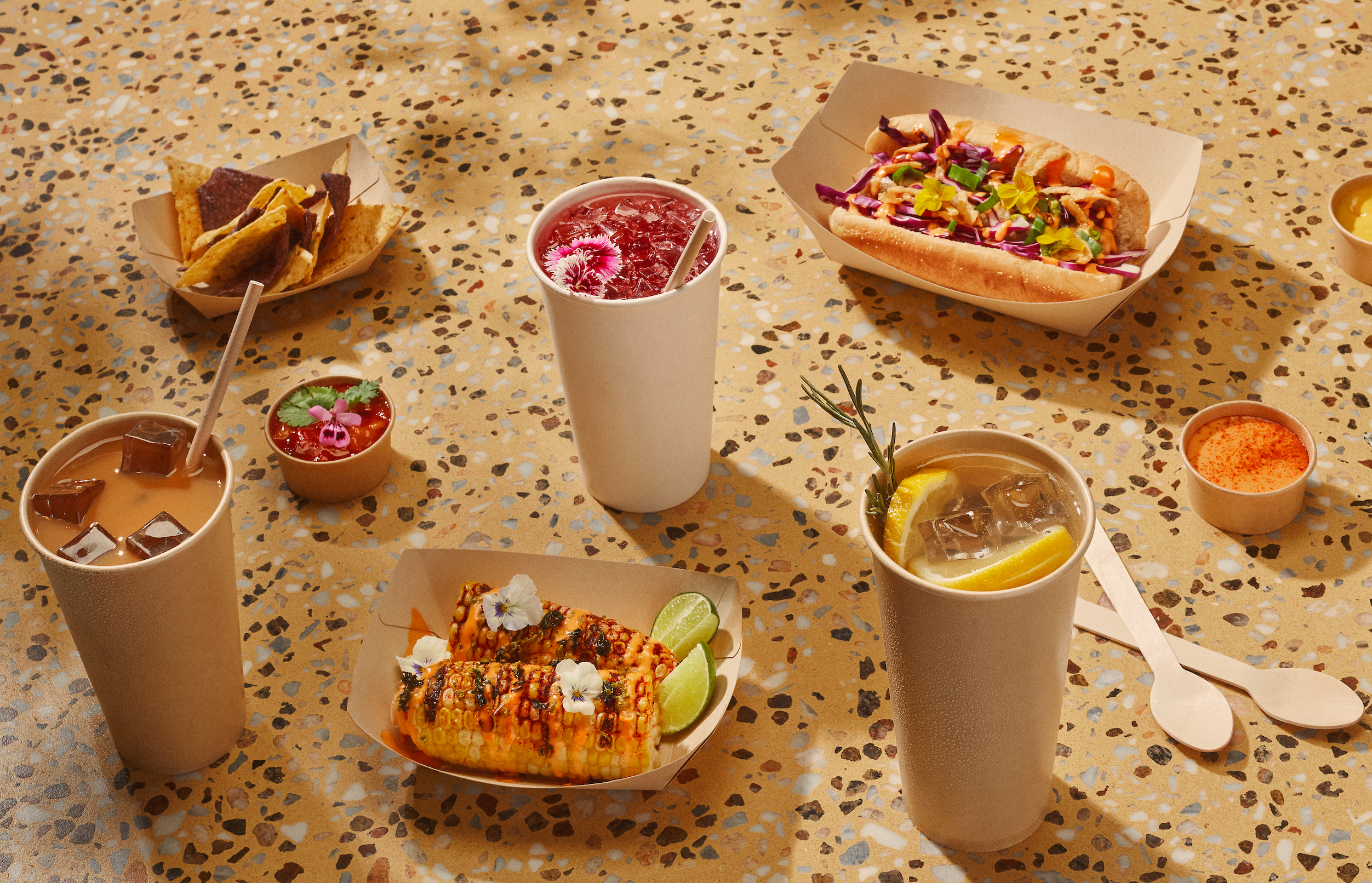 The image showcases an array of Kraft paper food containers with clear plastic lids, some open, containing bananas and a lemon on a vibrant purple background, suggesting themes of sustainable food packaging and takeaway.