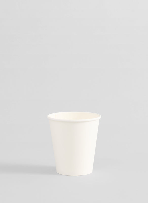 A plain white paper cup centered against a light gray studio background.